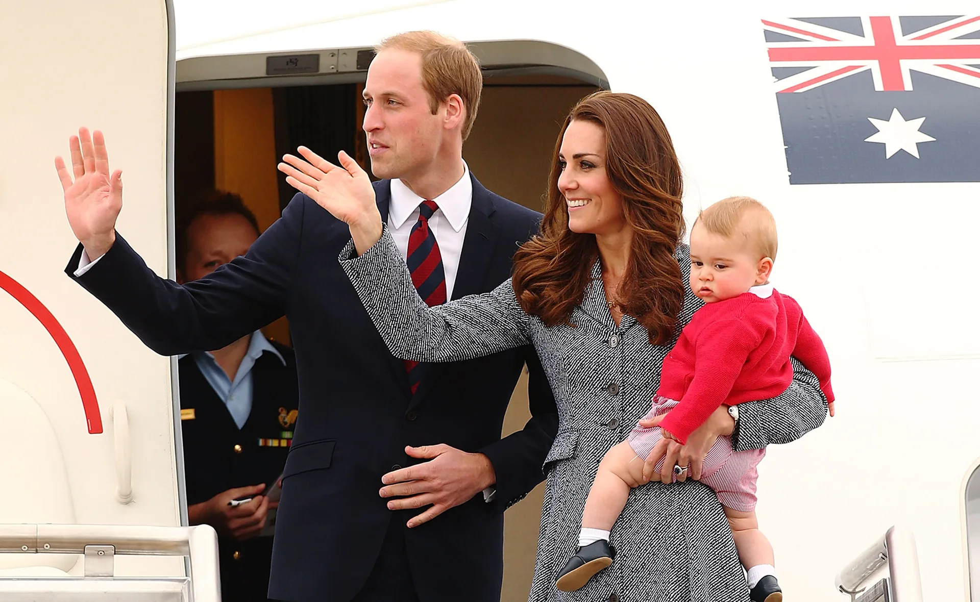 Family waving from aircraft door during Australia tour.