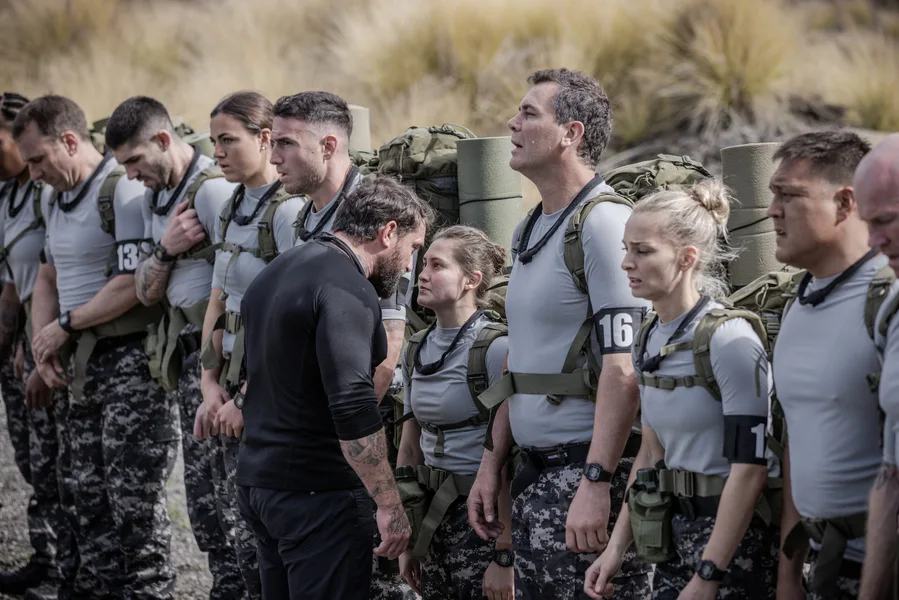 Participants in military gear during a challenge on SAS Australia 2022, standing in line outdoors.