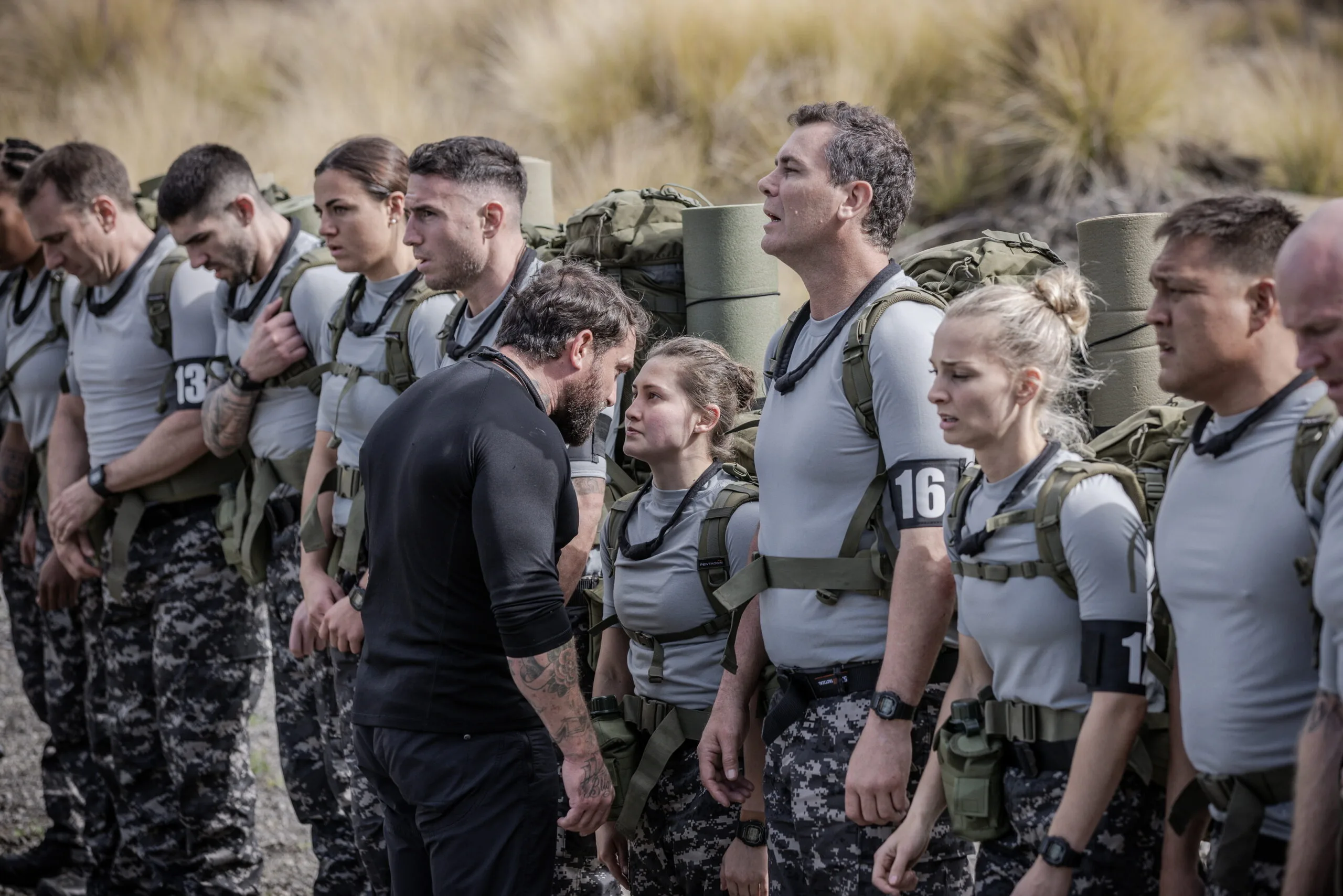 Participants in military gear during a challenge on SAS Australia 2022, standing in line outdoors.