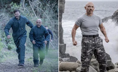 Two men in dark jumpsuits running, another man standing on rocks by the ocean in camouflage pants, arms tensed.