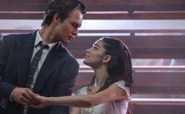 A couple dancing closely, gazing into each other's eyes, with soft lighting in the background.