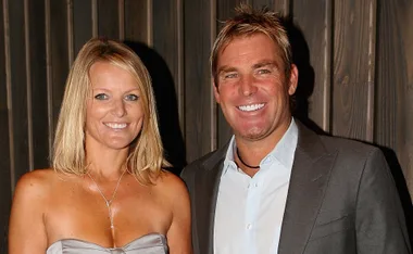 A smiling couple posing together at an event, both dressed formally.