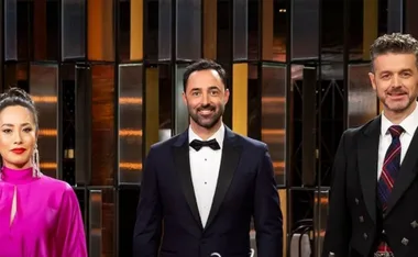 Three judges stand together on set for "MasterChef Fans and Favourites," dressed in formal attire.