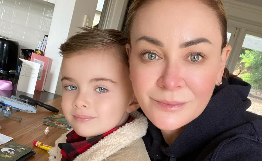 Woman and child smiling at a table with toys and cards scattered around.