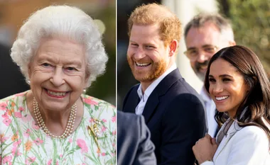 Queen Elizabeth II smiling, wearing a floral dress, beside a smiling Prince Harry and Meghan Markle outdoors.