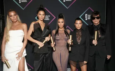 Five women posing with awards at a People's Choice event, dressed in stylish outfits.
