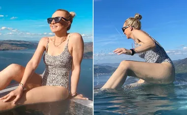 Woman in leopard print swimsuit enjoys sunny day by pool with scenic mountain and lake views.