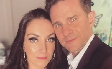 A man and a woman smiling closely together in a well-lit setting.