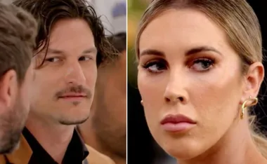 Two people sharing a tense moment, one glancing sideways, the other looking serious.