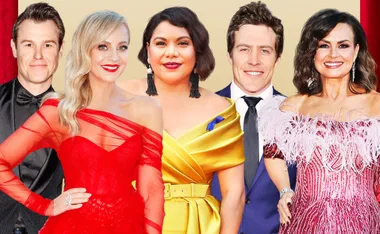 Group of celebrities dressed for a red carpet event in elegant attire, smiling at the camera.