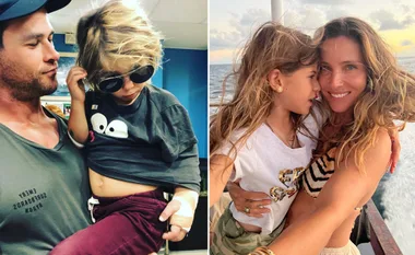 Father holding son with sunglasses; mother hugging daughter on boat, both smiling.