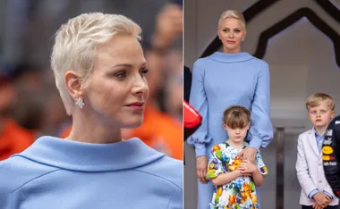 A woman in a light blue dress with short hair, stands with two children in formal wear.