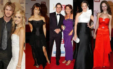 Red carpet event with formally dressed individuals posing for photos.