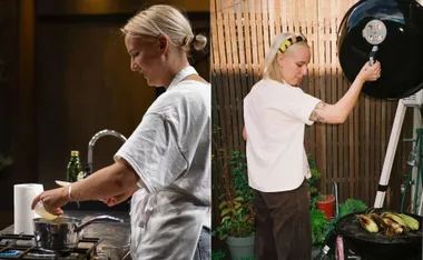 A person in a kitchen cooking and grilling corn outside, wearing a white t-shirt and apron.