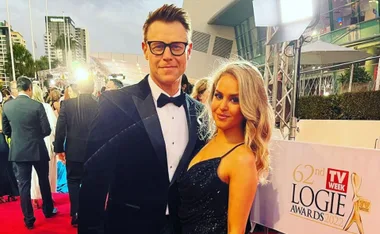 A man and woman in formal attire pose on the red carpet at the 62nd TV Week Logie Awards 2022.