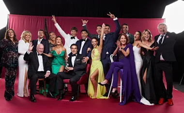 Cast of "Home and Away" celebrating together at Logies 2022, posing in formal attire with joyful expressions.