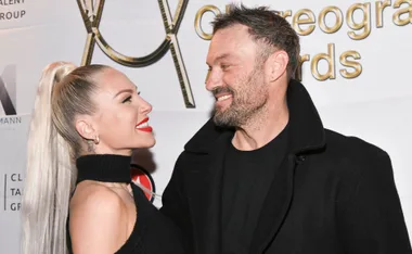 A couple smiling at each other on a red carpet at the Choreographer Awards event.
