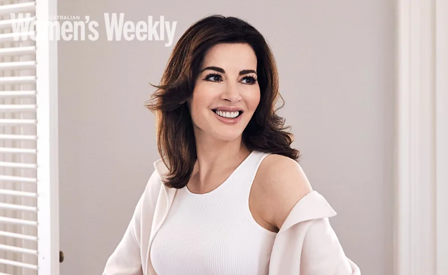 Smiling woman in a white outfit, posed indoors, with "Women's Weekly" text in the corner.