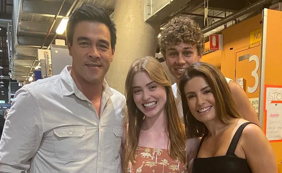 Four people smiling and posing together backstage on the set of "Home and Away."