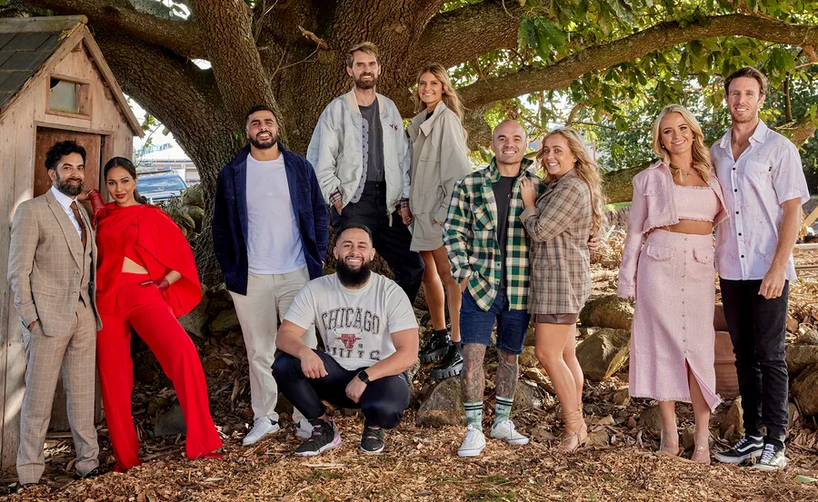 Group of "The Block" 2022 cast members posing outdoors near a tree.