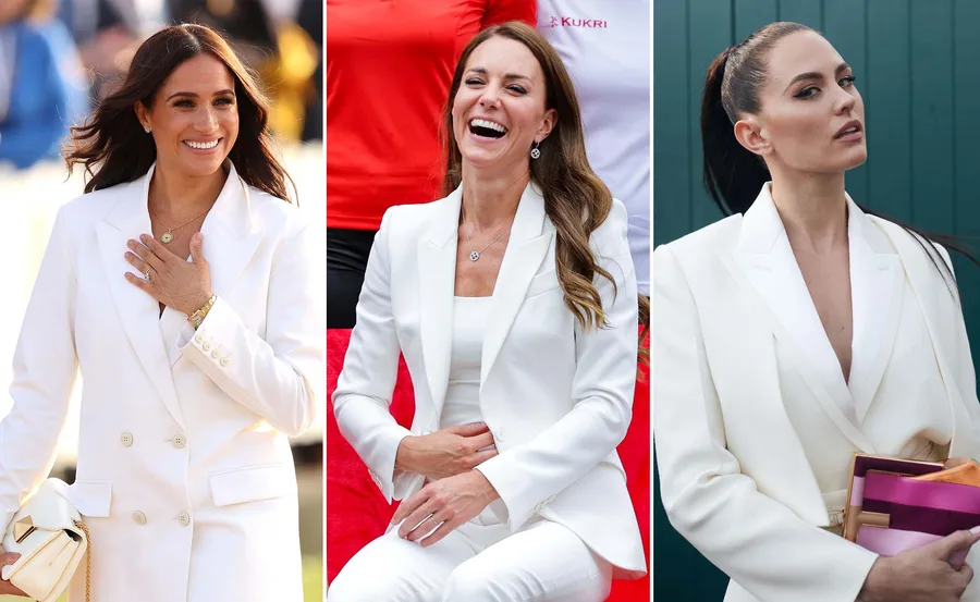 Women in white suits, smiling and posing at a public event.