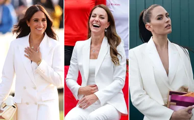 Women in white suits, smiling and posing at a public event.