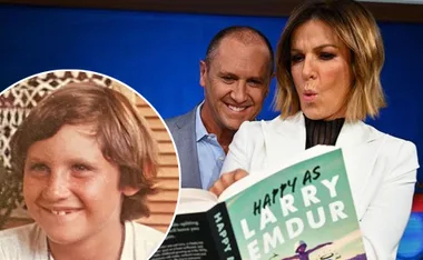 Two adults react to "Happy As Larry Emdur" book. Inset shows a smiling child.