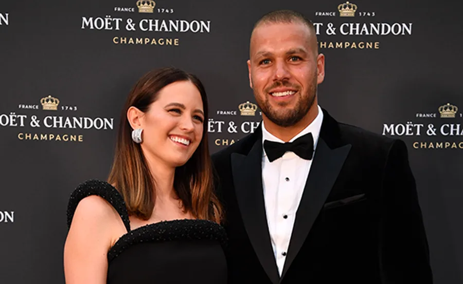 A smiling couple dressed formally at a Moët & Chandon event.