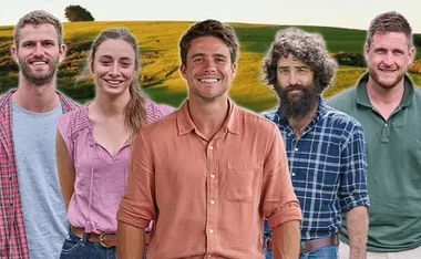 Five people smiling in casual attire standing outdoors with a grassy landscape in the background.