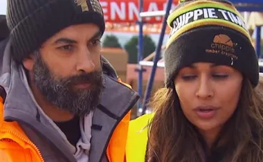A man and woman wearing beanies with "Chippie Timber" logos, standing outdoors, appear focused and contemplative.