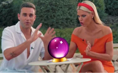Two people animatedly gesture around a glowing crystal ball on a table outdoors.