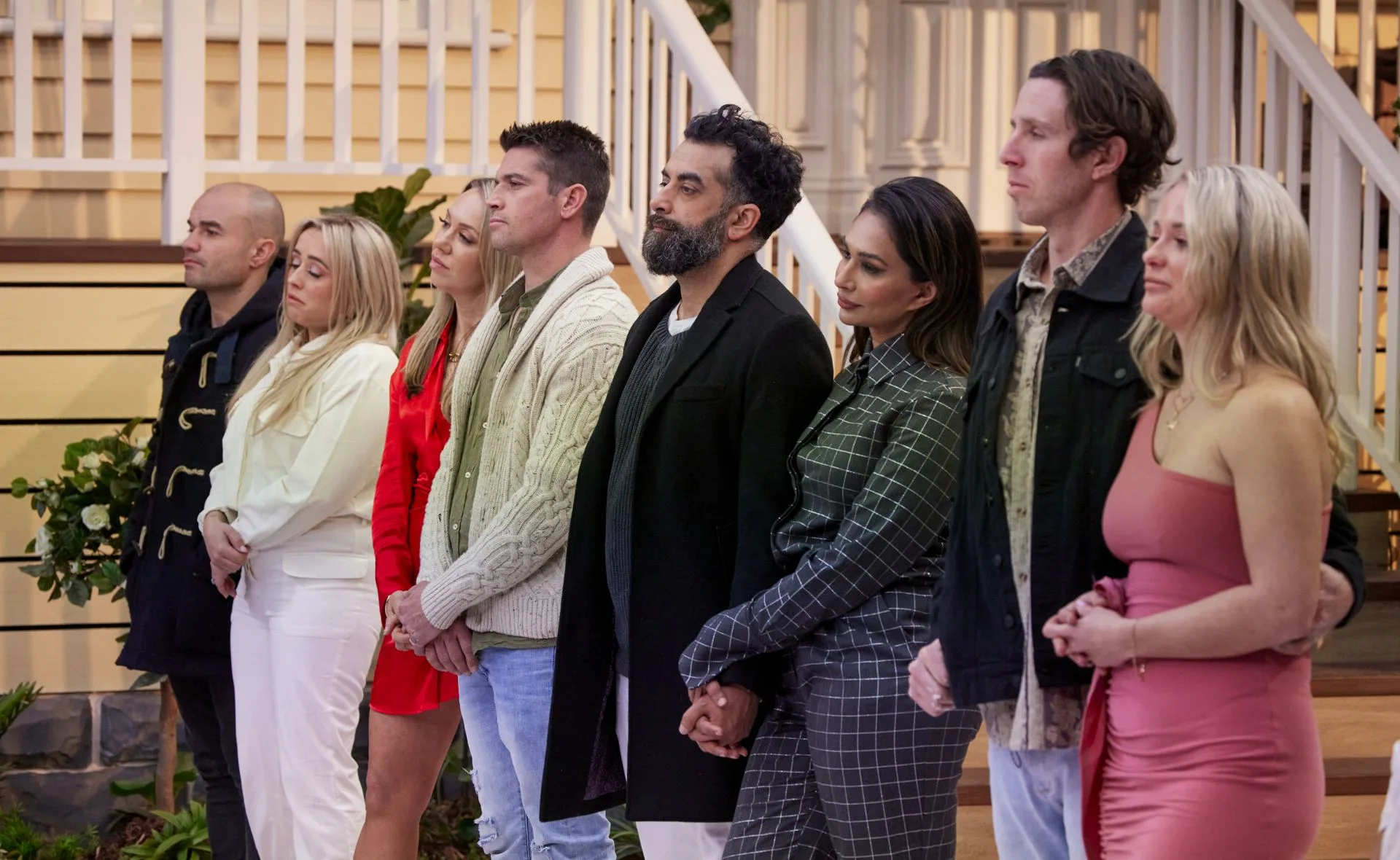 Contestants from The Block 2022 stand in a line during a house reveal, showing mixed emotions.