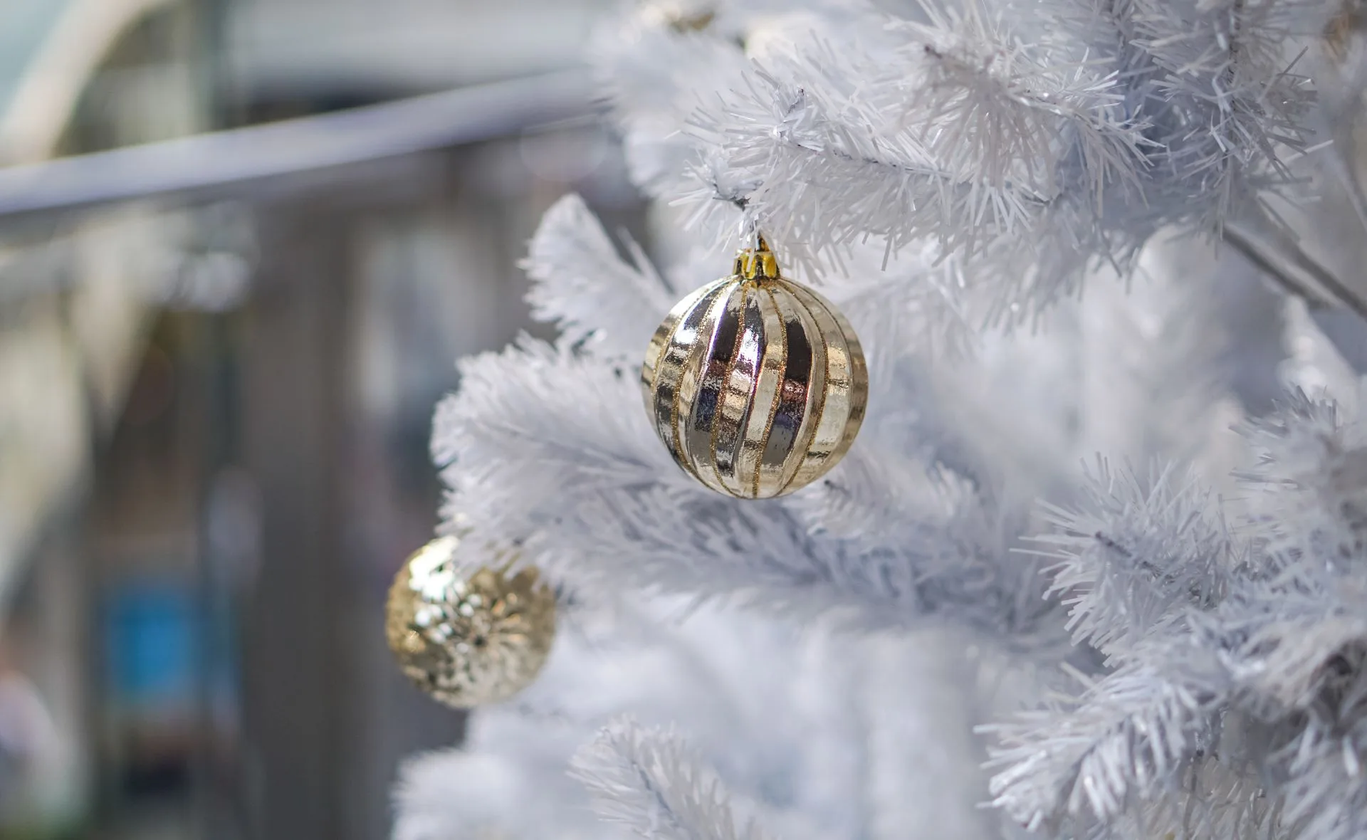 White Christmas tree with gold ornaments.