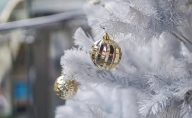 White Christmas tree with gold ornaments.