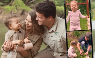 Family in Australia Zoo attire with a toddler, enjoying time outdoors. The toddler is smiling and exploring nature.