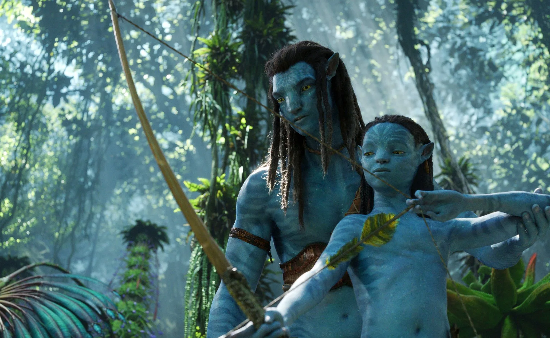 Two Na'vi characters practice archery in a lush, forest setting from the movie "Avatar."