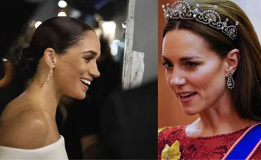 Two women side-by-side, one laughing with hair up, the other wears a jeweled tiara and earrings.