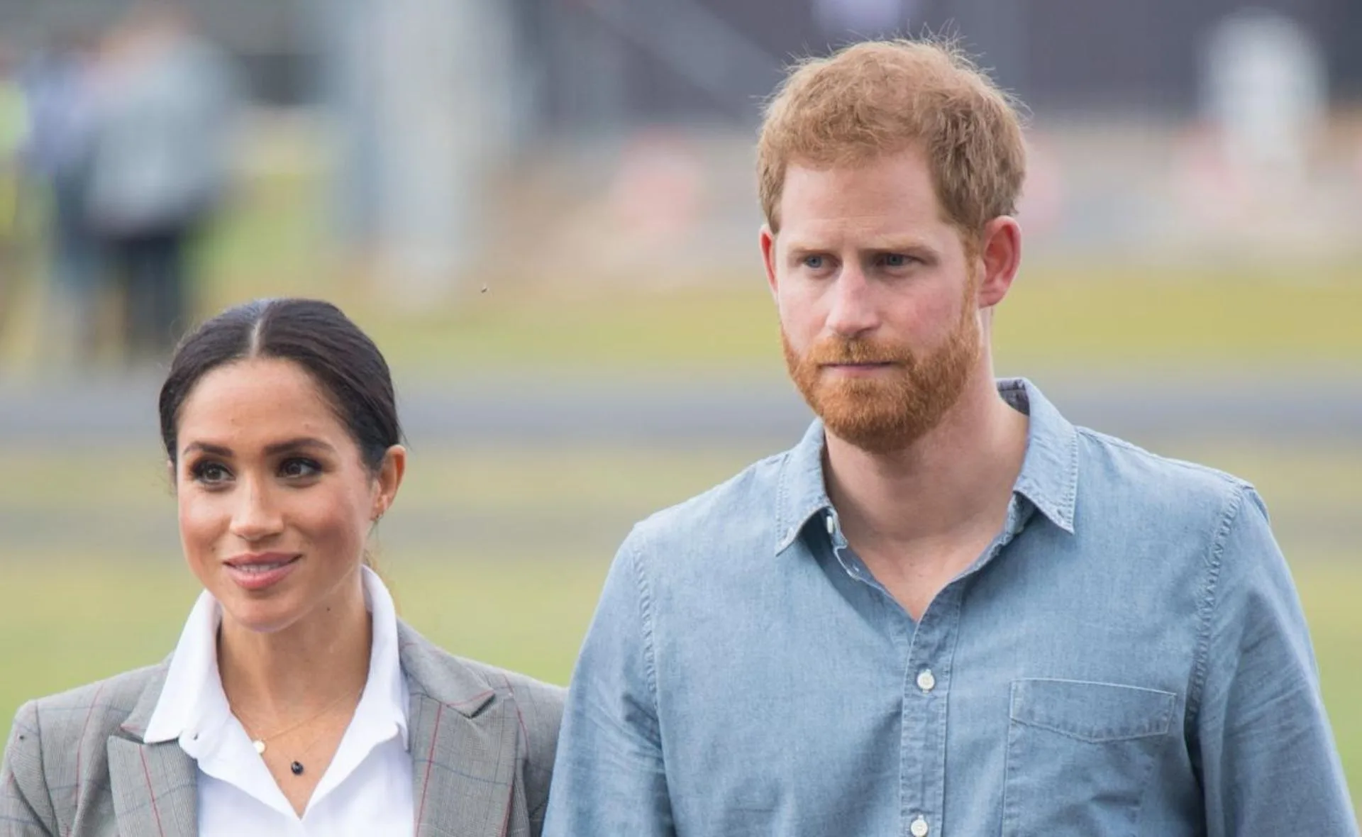Prince Harry and Meghan Markle walking outdoors during their Australian tour.