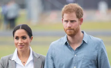 Prince Harry and Meghan Markle walking outdoors during their Australian tour.
