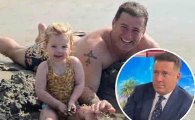 Father and daughter playing on a sandy beach, with an inset of the father in a suit on a TV set.