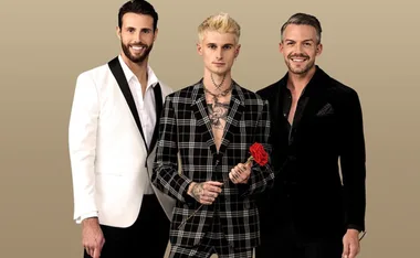 Three men in suits, one holding a red rose, standing against a plain background.