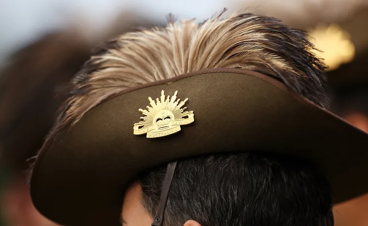 Australian Army slouch hat with emu plumes and gold Rising Sun badge, worn by a person.