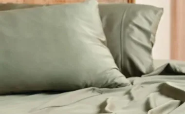 Green bamboo bed sheets and pillows on a bed, showcasing their smooth texture and soft appearance.