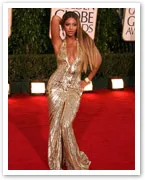 A celebrity poses in a shimmering gold gown on the red carpet at the Golden Globe Awards.