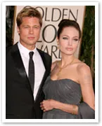Two individuals posing on the red carpet at the Golden Globe Awards, wearing formal attire.