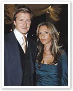 A couple dressed in formal evening attire poses together at an event.