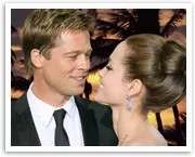 Two people smiling at each other against a sunset and palm trees background.