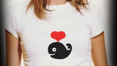 A person wearing a white T-shirt with a black whale and a red heart design.