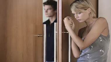 Woman scared and hiding from her partner's domestic abuse