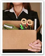 Person holding a box of office supplies, symbolizing job loss and career transition.